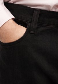 Μαύρο τζιν παντελόνι με απαλή υφή, που διαθέτει πλαϊνή τσέπη και διακριτική ραφή σε τονικό χρώμα. Η μέση είναι ενσωματωμένη και ανθεκτική.