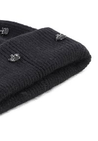 Cappello di lana nera lavorato a maglia con texture a coste, impreziosito da accenti di gemme nere decorative sulla parte anteriore. Design morbido e piegato.
