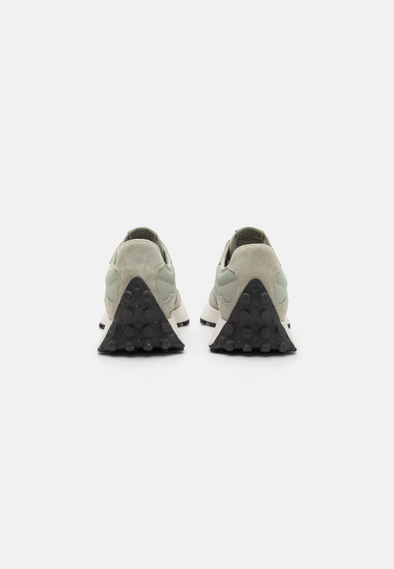Die Sneakers verfügen über ein hellgraues Wildleder-Obermaterial mit einem strukturierten mintgrünen Mesh-Panel. Die schwarze Gummi-Außensohle hat eine dreieckige Form mit kreisförmigen Griffen.