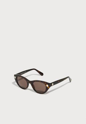 Ochelari de soare cu model tartău, în formă de ochi de pisică, cu lentile maro închis și accente de pietre prețioase pe partea din față. Cadru din plastic neted și brațe subțiri.