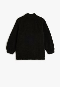 Zwarte, donzige fleece jacket met een hoge kraag, raglanmouwen en een rechte snit. Heeft elastische manchetten en een zachte, gestructureerde afwerking.