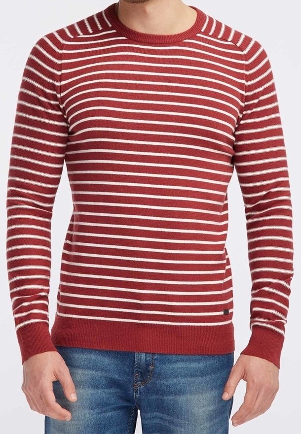 Maglione a righe rosse e bianche con collo rotondo, polsini e orlo a coste. Realizzato in un materiale a maglia testurizzato. Indossato con jeans blu.