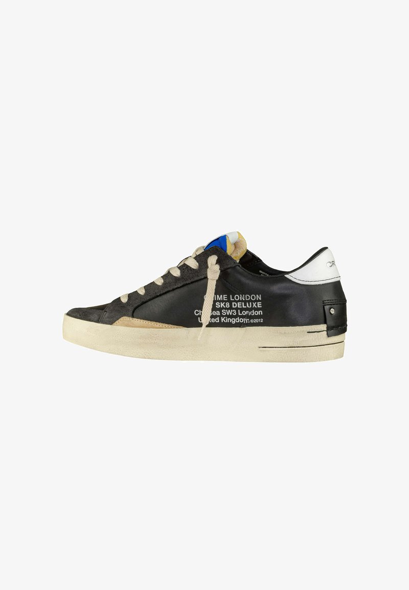 Sneaker nera e grigia con una tomaia testurizzata, lacci crema e suola crema. Presenta un logo stampato sul lato e un accento blu sulla linguetta.