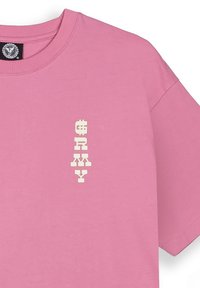 Camiseta de algodón rosa con un gráfico de texto vertical en blanco que dice "ARMY". Cuello redondo y mangas cortas, con una textura suave.