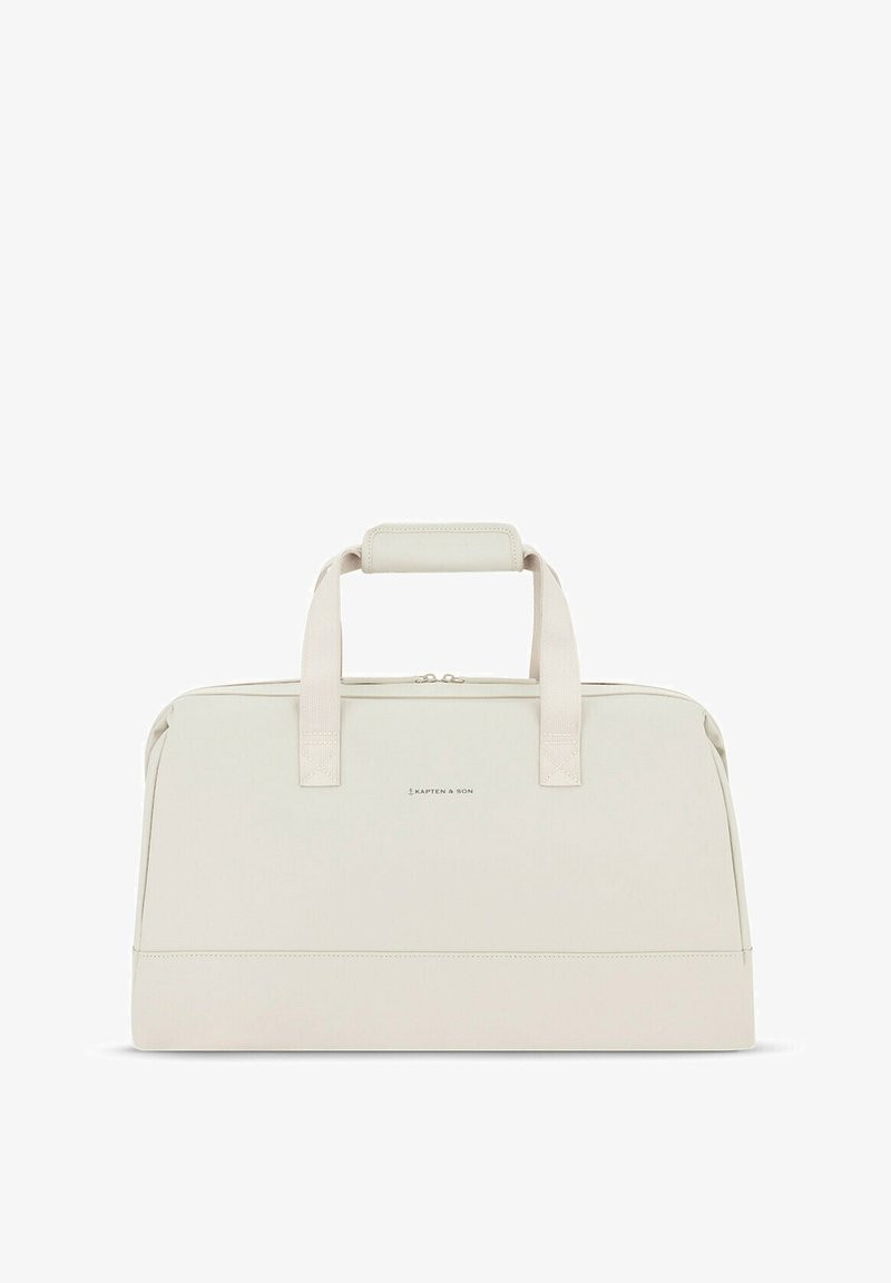 Světlobéžová taška na cesty s elegantním designem, vyrobená z hladkého materiálu. Obsahuje dvojité rukojeti a horní zip, s logem na přední straně.