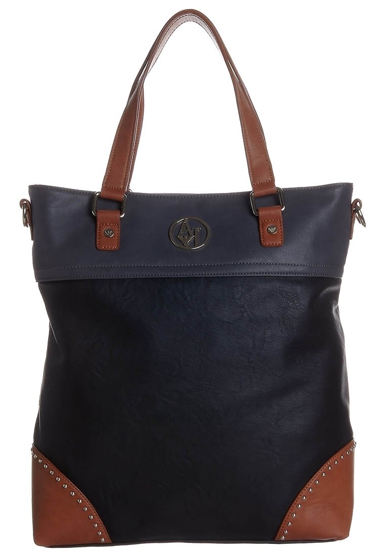 Sac fourre-tout avec corps bleu marine, bordure supérieure bleu foncé, poignées marron et accents marron aux coins avec clous en métal et logo rond à l'avant.