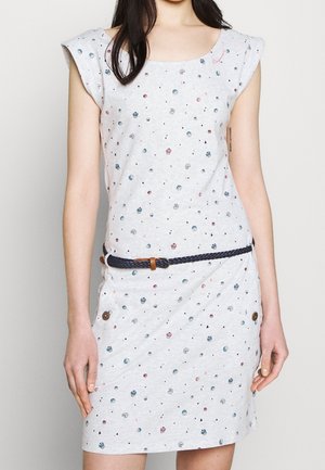 Woman wearing a short-sleeve light gray dress with small multicolored circular patterns and a black woven belt with a brown buckle.