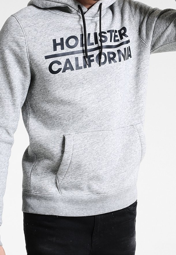 Felpa grigia con cappuccio e coulisse, caratterizzata da una scritta nera "HOLLISTER CALIFORNIA", polsini elastici e una tasca a marsupio frontale.