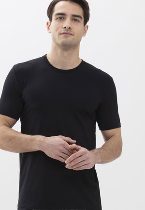 T-shirt noir à manches courtes en coton doux. Doté d'un col rond classique et d'un design épuré, ajusté autour du torse.