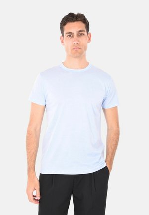 T-shirt in cotone azzurro chiaro con maniche corte e scollatura rotonda, caratterizzata da una superficie liscia e una vestibilità classica, abbinata a pantaloni neri.