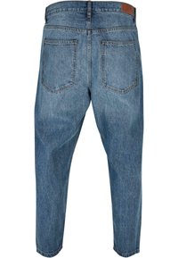Jeans de denim de color azul claro con corte relajado, que cuentan con dos bolsillos traseros, piernas rectas y una sutil textura desgastada.