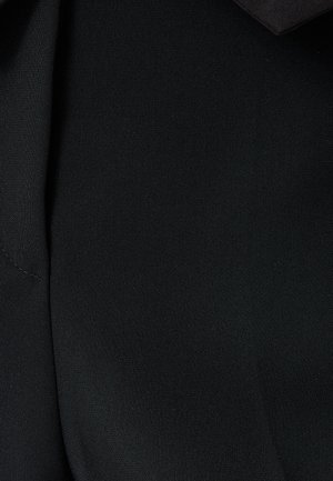 Mustan kankaan lähikuva, sileä rakenne, jossa on lievä kiilto. Sisältää sauman ja taitetun muotoiluelementin.