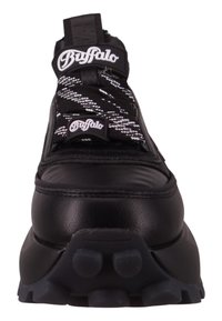 Zapatilla deportiva negra con parte superior de cuero liso y malla texturizada, con cordones de rayas blancas y negras. Suela de goma gruesa con tracción.