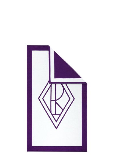 Asciugamano bianco con bordo viola, un angolo piegato, con un monogramma geometrico viola a forma di diamante al centro.