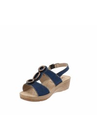 Sandalo blu navy in materiale scamosciato, con due elementi circolari, cinturino alla caviglia regolabile e una suola a zeppa testurizzata di colore chiaro.