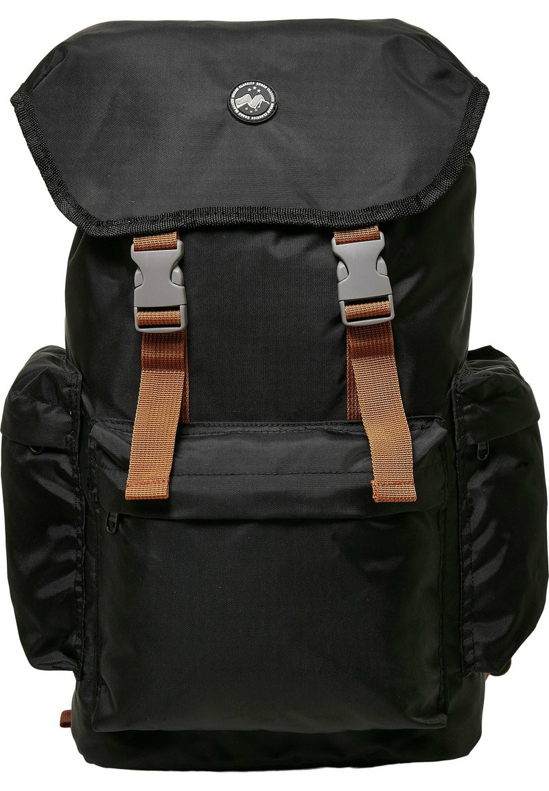 Sac à dos noir avec un rabat supérieur replié, des sangles et des éléments en métal bruns, plusieurs poches et une finition en tissu texturé. Logo au centre en haut.