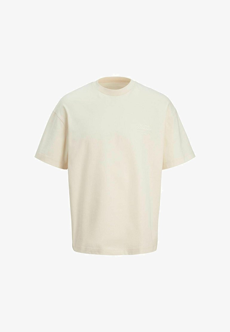 Kremo spalvos medvilnės marškinėliai trumpomis rankovėmis, apvaliu kaklu ir subtiliu grafikiniu akcentu viršutinėje kairėje krūtinės pusėje.