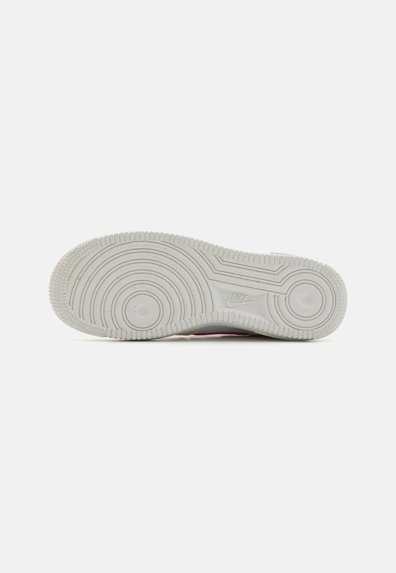 Nike Sneaker-Außensohle aus hellgrauem Gummi mit kreisförmigen Traktionsmustern und einer strukturierten Oberfläche, versehen mit gesprenkelten Details.