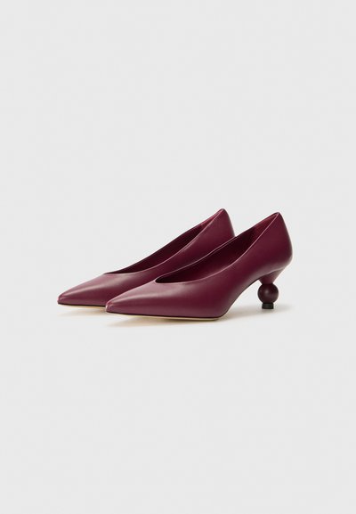 Burgundy-hunajanahka korkeakorkoiset kengät, joissa on teräväkärkinen muoto ja ainutlaatuinen pyöreä korkodesign. Sileä pinta, jossa on matala leikkaus kengän yläosassa.