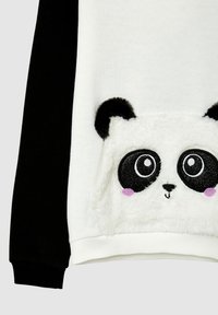 Felpa bianca e nera con dettaglio della tasca a forma di faccia di panda pelosa, dotata di grandi occhi neri e bianchi e accenti rosa.