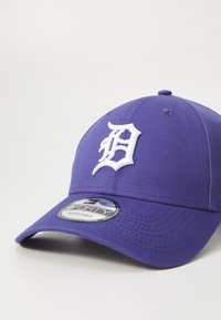 Gorra de béisbol morada con un logo "D" bordado en blanco. Cuenta con una visera curva y tela texturizada para mayor durabilidad. Ajustable.