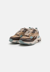 Sneakers chunky cu un amestec de materiale în nuanțe de bej, maro și bleu deschis. Dispun de țesătură texturată, sistem de șireturi frontal și talpă cu marcă.