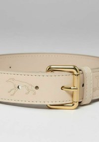 Beige leren riem met een gouden metalen gesp. Voorzien van een geperst windhondenmotief en kleine studs, met zichtbare stiksels langs de randen.