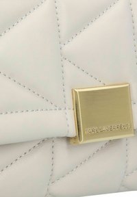 Gequilted crème leren handtas met een gouden metalen sluiting met het Karl Lagerfeld-logo. Gestikte details over het hele oppervlak.