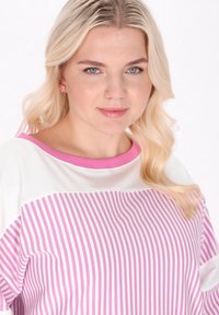 Vit och rosa randig topp med en vid halsringning och korta ärmar. Strukturerad tyg med mjuka rosa accenter och en lös passform.