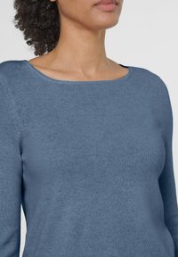 Blaues, langärmliges Strickoberteil mit rundem Halsausschnitt und glatter Textur. Verfügt über subtile, tonal abgestimmte Nähte entlang der Schulternaht.