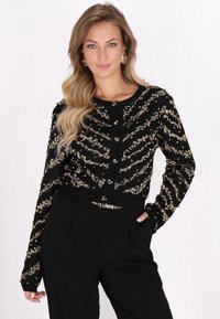 Cardigan lavorato a maglia nero con un motivo a zigzag dorato e perline decorative, dotato di bottoni a forma di cuore e vita aderente.