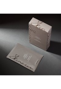 Skinesis-Gesichtsmaske Verpackung in mattem Hellgrau mit filigraner schwarzer Schrift. Box mit abgerundeten Ecken, mit minimalistischem Branding, enthält einen Deckel.
