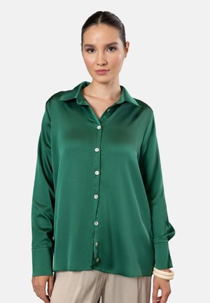 Green satin blouse with a collar, long sleeves, and buttoned front. Features a smooth texture and a slightly loose fit.