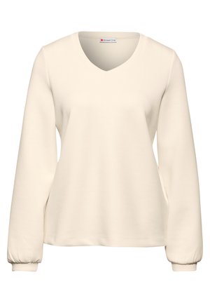Sudadera beige de cuello en V con mangas largas y fruncidas; tejido suave; diseño simple; sin patrones ni acentos visibles.