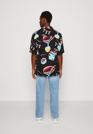 Camicia nera a maniche corte con una stampa vivace di bicchieri da cocktail e dadi, vestibilità rilassata, tessuto leggero e orlo arrotondato.