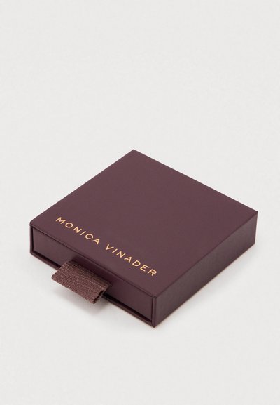 Purple cardboard jewelry box featuring a gold logo, textured fabric pull tab, square shape, and smooth finish.