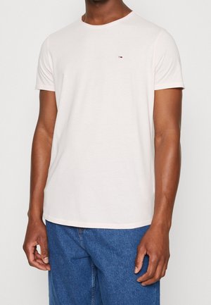 Jasnoróżowa koszulka z krótkim rękawem, wykonana z miękkiego materiału, z okrągłym dekoltem i małym haftowanym logo na piersi.