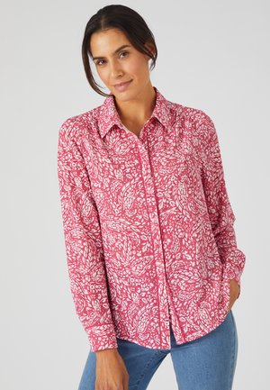 Lange mouwen shirt in roze met een wit bloemenpatroon, met een knoopsluiting aan de voorkant, kraag en een relaxte pasvorm. De stof lijkt lichtgewicht.