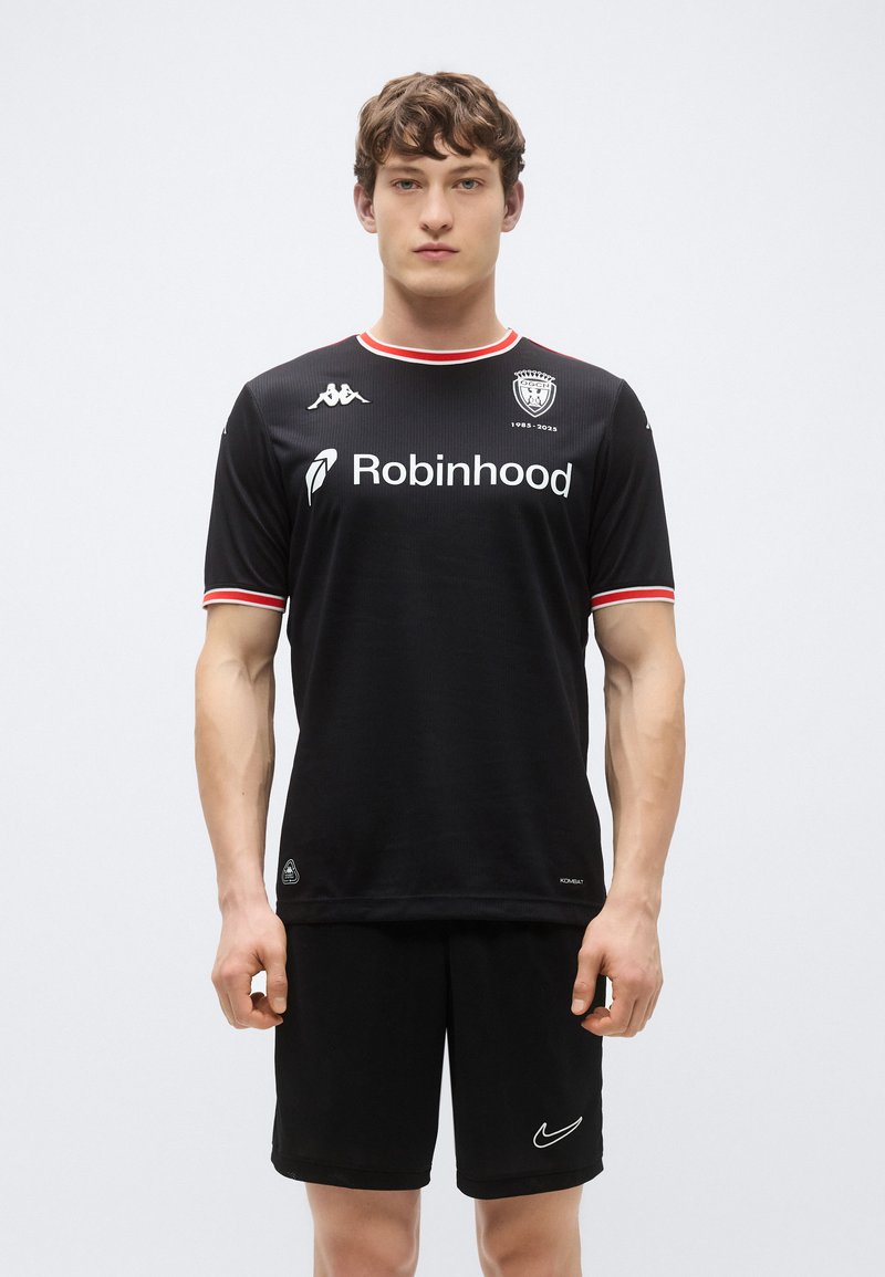 Maillot de sport noir à manches courtes, avec un col et des accents rouges, logo Kappa sur la poitrine, et le texte "Robinhood" affiché de manière bien visible.