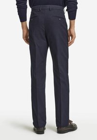 Marineblaue Hose aus glattem Stoff mit geradem Bein. Die Rückansicht zeigt zwei knöpfbare Taschen und einen Gürtelschlaufenbund.