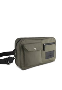 Olivgrön nylonaxelväska med blixtlås, framficka och justerbar rem; har strukturerad tyg och gummilogo.
