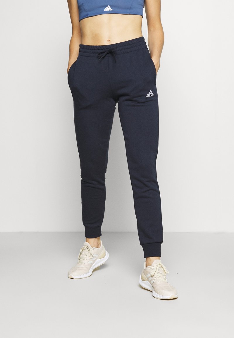 Pantalones jogger color azul marino fabricados con tejido suave, con cinturilla elástica con cordón, puños en los tobillos y logo bordado en el muslo izquierdo.