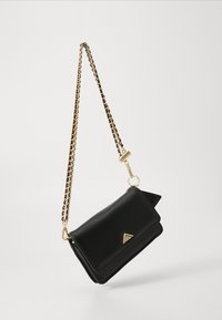 Black leather crossbody bag with a gold chain strap, featuring a triangular accent on the front, and a flap closure. Smooth texture.