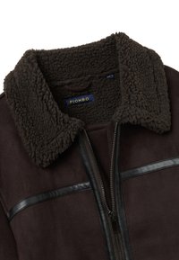 Braune Wildlederjacke mit einem Kunst-Lammfellkragen, Reißverschluss und schwarzen Lederakzenten auf der Brust. Das Etikett trägt die Aufschrift "PIOMBO."