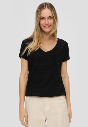 Haut noir à manches courtes avec un col en V, présentant un motif rayé texturé. Tissu doux, coupe décontractée et ourlet légèrement arrondi.