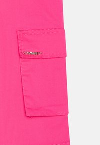 Roze cargobroek met een klepzak en zilverkleurige hardware, met de merknaam "TWINSET." Glad materiaal met een recht model.
