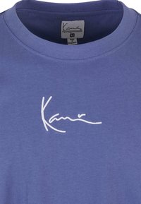 Blue cotton t-shirt with a crew neck and embroidered white logo, featuring a tag labeled "Medium" and "Made in Bangladesh."