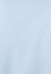 Tela de algodón azul claro con una textura suave, apariencia ligeramente jaspeada y un brillo sutil. Material ligero y elástico.