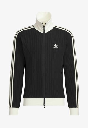 Zwart geribbelde jas met ritssluiting, witte accenten, hoge kraag en zijzakken. Heeft een wit driestrepenontwerp op de mouwen en het Adidas-logo.