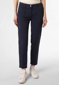 Dunkelblaue Baumwollmix-Hose im Slim Fit, mit einem Knopfverschluss und Seitentaschen, kombiniert mit cremefarbenen Sneakers.